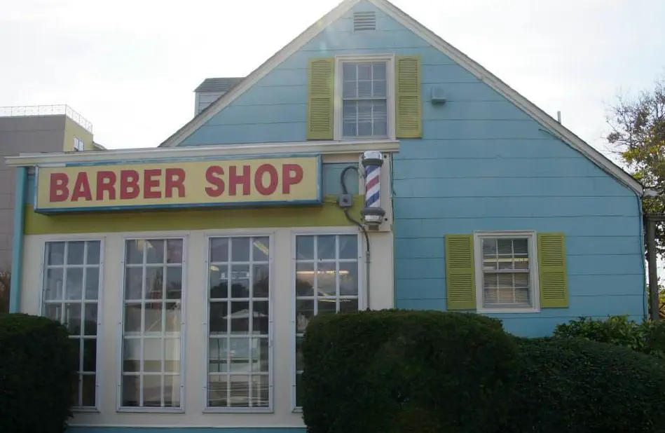 The sky-blue cottage at 400 32nd Street with its red Barber Shop board, barber pole and yellow shutters